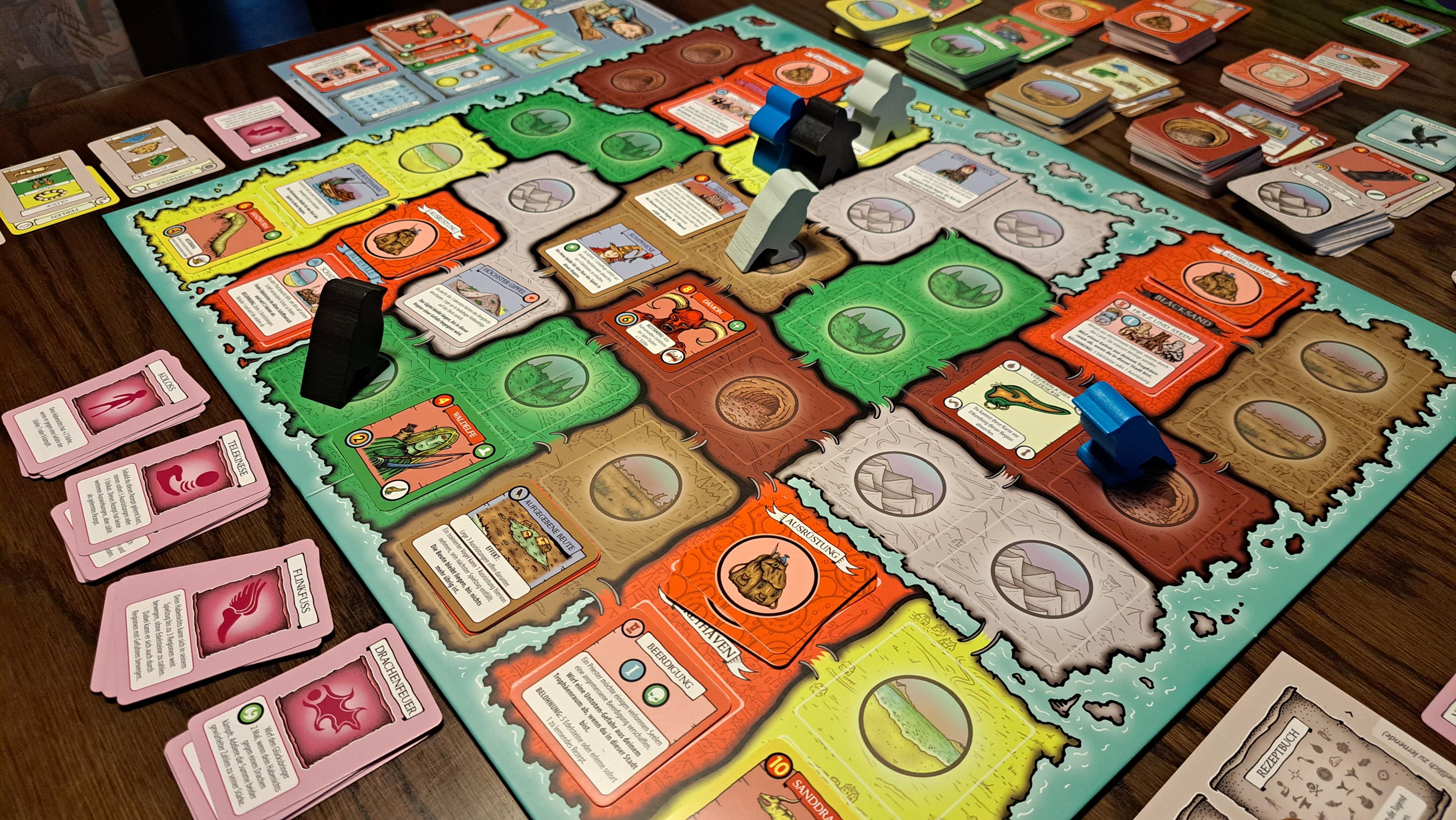 A closer view of the main board. It represents an island with 4 cities (red) and different terrain. Each player has 2 meeples (a pauper and a bird) to explore the island and resolve encounters.
